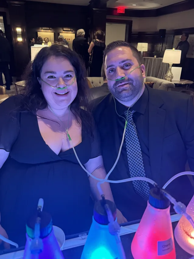 Two guests smiling at a colorful bar during an evening gathering