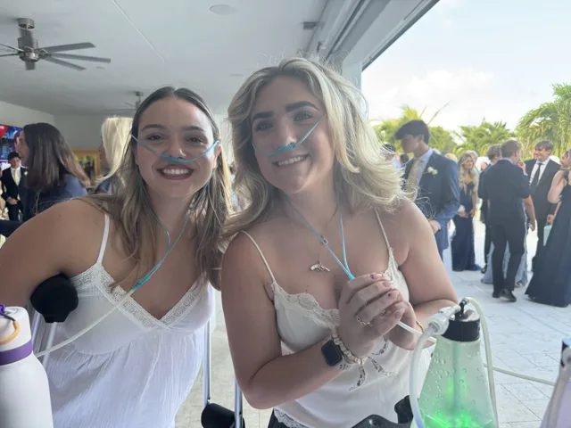 Two guests smiling at a celebration beside an open terrace