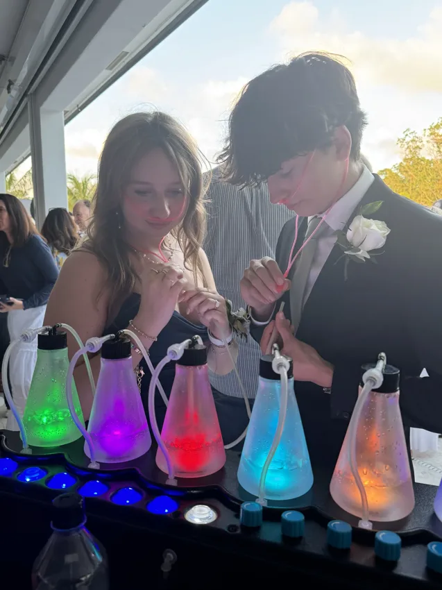 Two formally dressed guests exploring the aroma bottles together