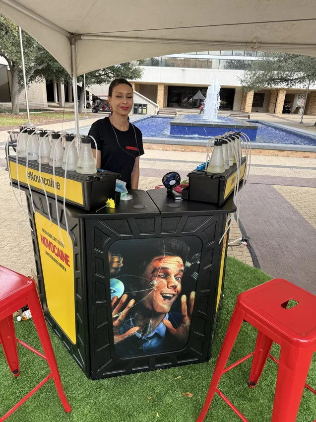 An attendant at a yellow branded outdoor oxygen bar